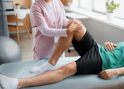 Physiotherapist massaging knee of patient for recovery