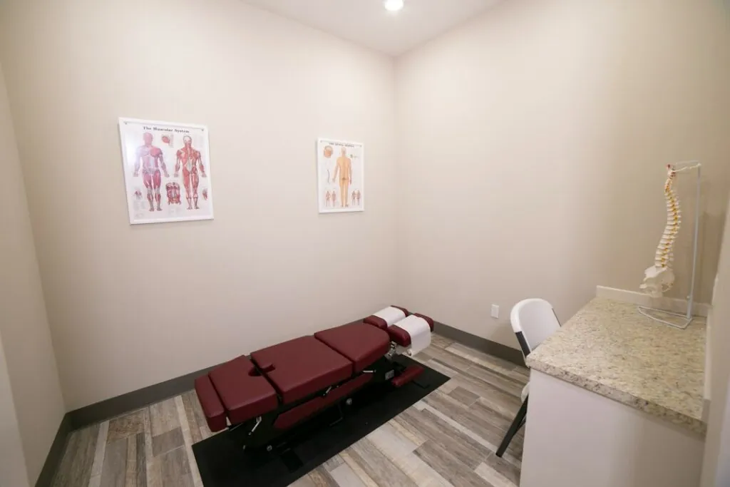 Private treatment room with a treatment table and anatomy posters