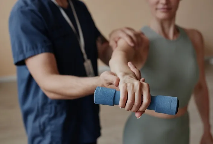 closeup-patient-training-with-dumbbells-together-with-therapist-hospital-1-3