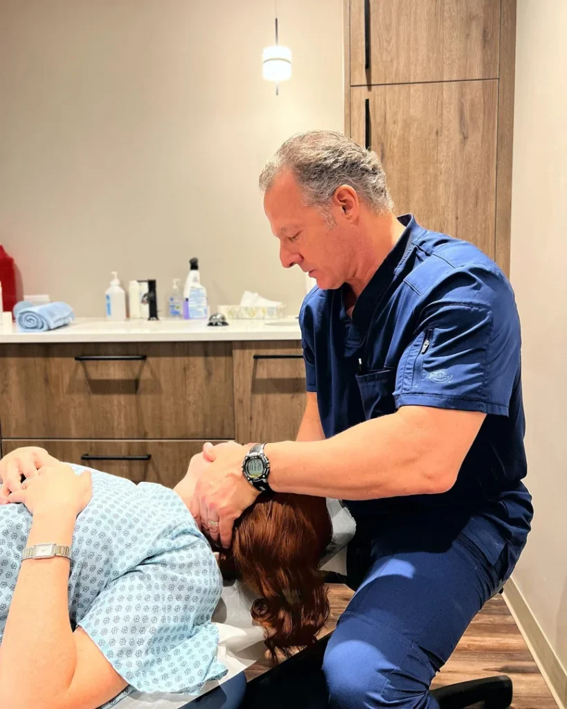 Chiropractor performing a neck adjustment on a patient at Global Clinic