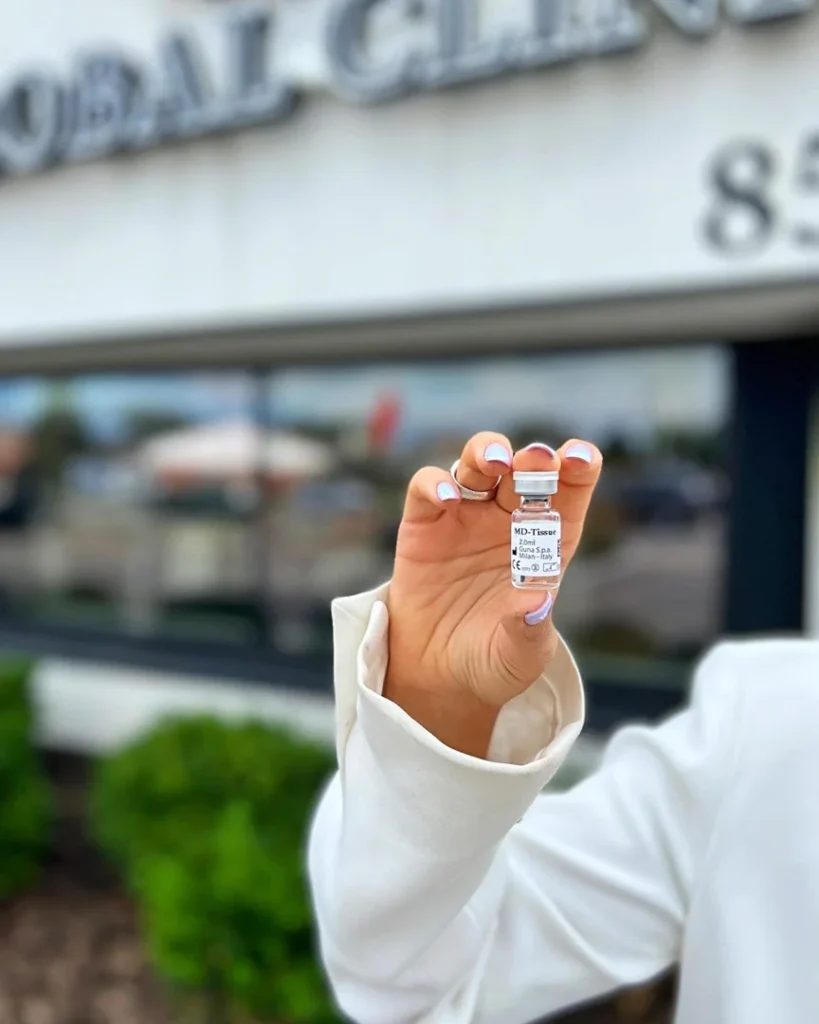 Small vial held up in front of the Global Clinic building in Niles
